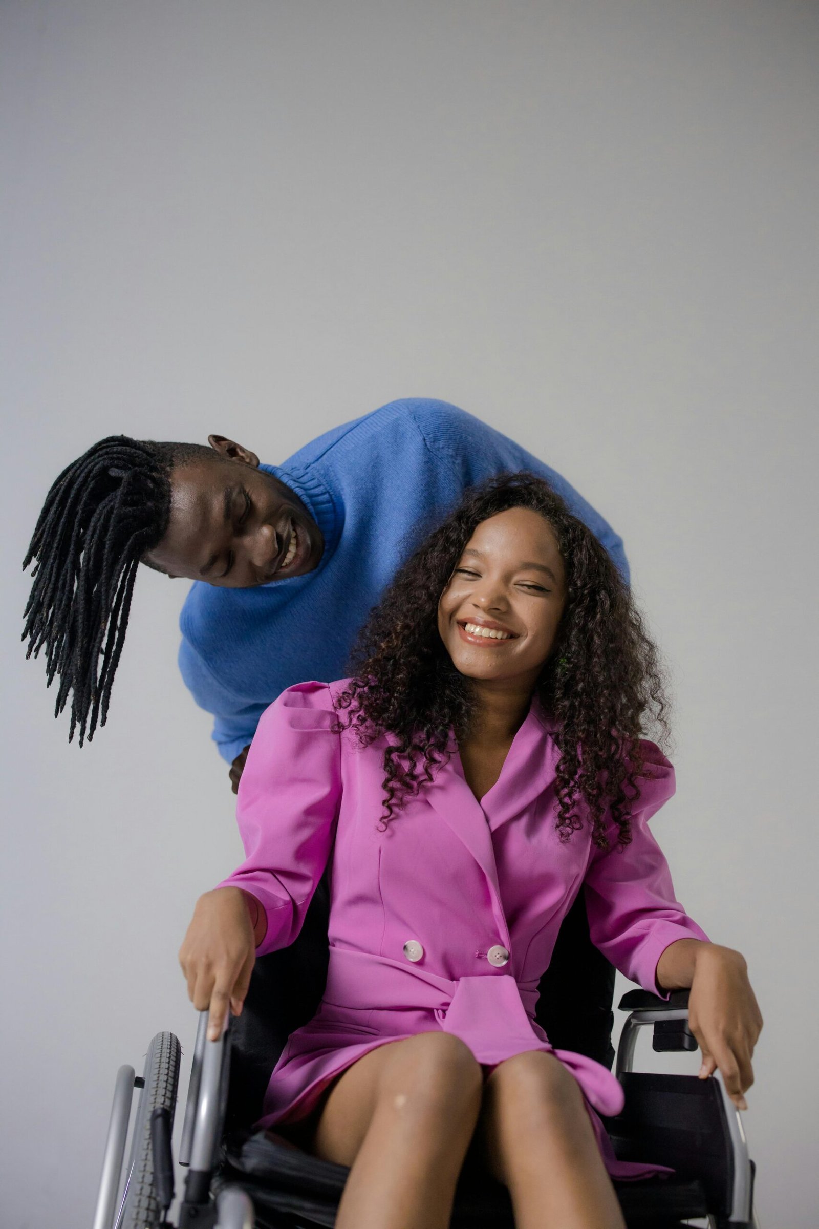 An African American couple, one using a wheelchair, sharing a joyful moment together.